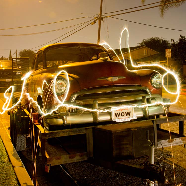 Long exposure nighttime photograph of a classic car with light trails